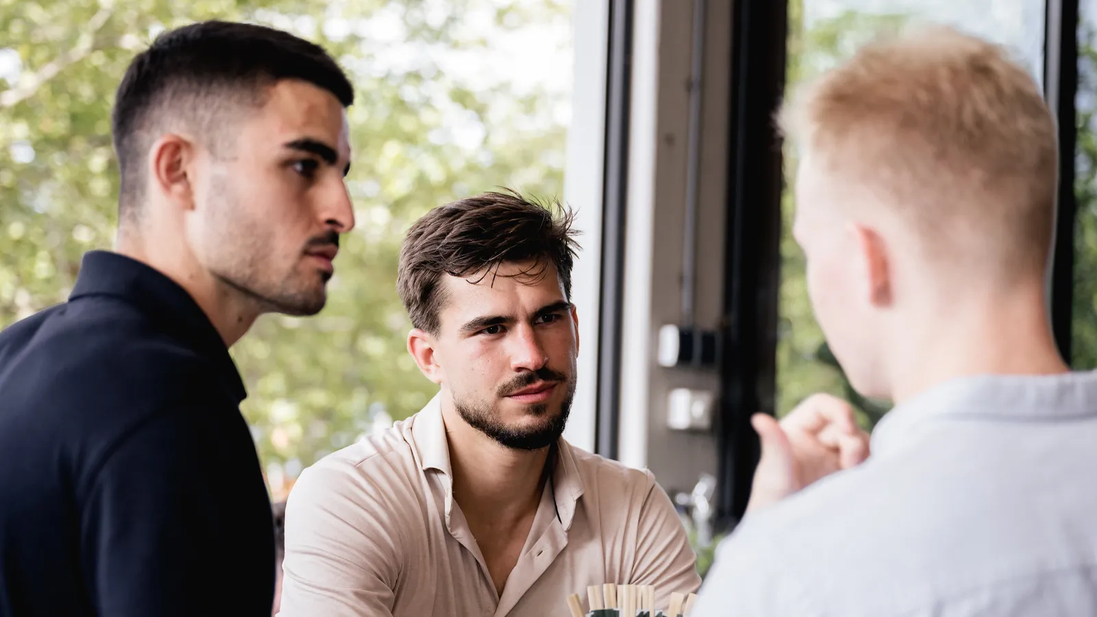 Tim Tielkemeijer in gesprek met twee ondernemers aan een tafel